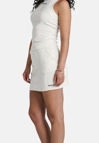 Top bianco senza maniche e gonna coordinata realizzata in tessuto liscio, con cuciture laterali e il logo del marchio "SIXTHJUN" sulla gonna.