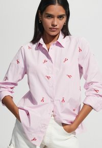 Pink button-up shirt featuring horizontal stripes and red lobster embroidery. Long sleeves, relaxed fit, and textured fabric.