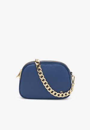 Petit sac bandoulière en cuir bleu marine avec bords arrondis et une épaisse chaîne en or sur un fond blanc.