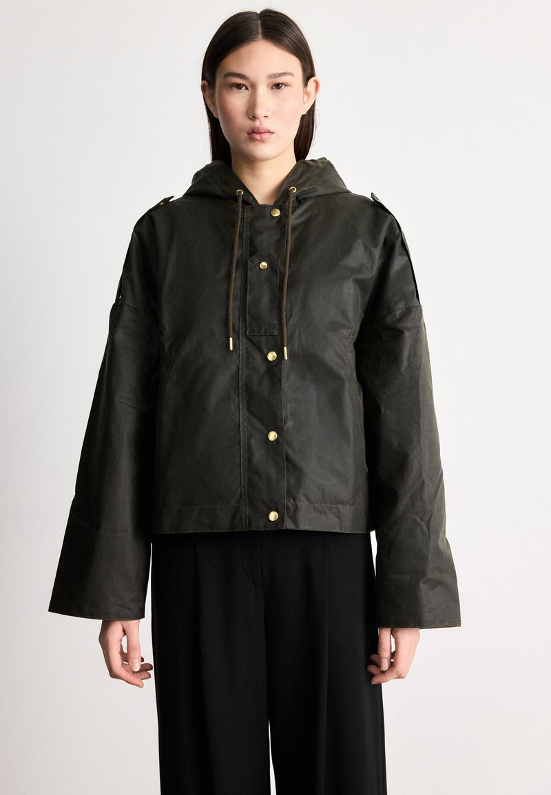 Tume roheline lühike jope kapuutsiga, kuldsete nööpidega, paelaga ja laiade varrukatega. Valmistatud veekindlast materjalist.