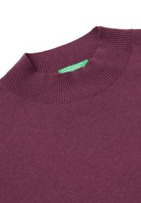 Fioletowy sweter z okrągłym dekoltem, wykonany z miękkiej dzianiny z prążkowanym wykończeniem. Posiada zieloną metkę z logo "United Colors of Benetton" wewnątrz kołnierza.
