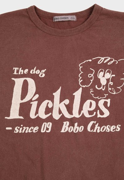 Maglietta marrone con testo bianco "The dog Pickles since 09 Bobo Choses" e un semplice disegno a linee del volto di un cane riccio.