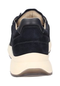 Baskets en daim bleu marine avec un contrefort de talon en cuir noir lisse, semelle crème et détails de couture contrastants. La vue arrière montre le rembourrage intérieur.