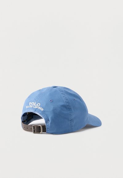 Μπλε καπέλο μπέιζμπολ Polo Ralph Lauren με ρυθμιζόμενο καφέ δερμάτινο λουράκι, εμφανιζόμενο από πίσω σε απλό ανοιχτό φόντο.