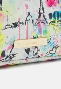 Pestrobarevná prošívaná kabelka se světlým pozadím a černými skicami památek a srdcí, doplněná zlatou destičkou "ALDO".
