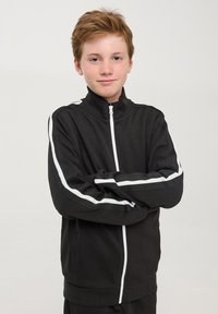 Giubbotto zip-up nero con strisce bianche ai lati, collo e polsini a costine, realizzato in tessuto morbido. Tasche frontali e vestibilità comoda.