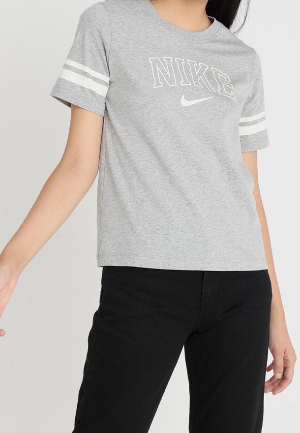Camiseta gris de manga corta con el logo "NIKE" en blanco en el pecho y dos rayas blancas en cada manga. Fabricada con una suave mezcla de algodón.