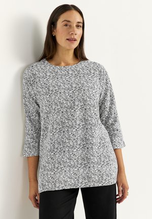 Haut à manches trois-quarts ample avec un motif texturé noir et blanc. Tissu doux avec un col rond et un ourlet droit.