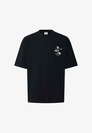 T-shirt noir à manches courtes avec un petit motif floral blanc et le texte « Soul Est. 1999 » sur le côté gauche de la poitrine.