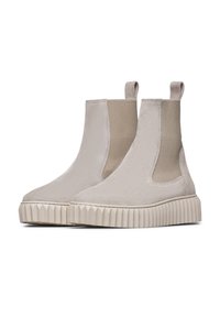 Bottines à cheville en beige avec élastiques sur les côtés, finition en daim, équipées d'une semelle en caoutchouc nervurée et de languettes pour un enfilage facile.