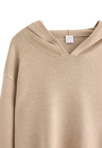 Beige hoodie gemaakt van zachte stof, met een V-hals ontwerp en geribbelde accenten op de mouwen en zoom, met een label zichtbaar aan de binnenkant.