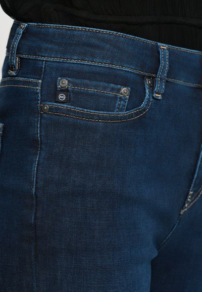 Mörkblå denimjeans med en klassisk design med fem fickor, kontrasterande gul sömnad och en liten märkeslapp på framfickan.