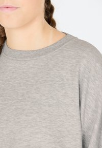 Grijze sweatshirt met een ronde halslijn, geribbelde kraag en zachte textuur. Heeft een ontspannen pasvorm en een subtiel gemêleerd patroon.