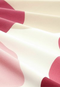 Tessuto caratterizzato da una stoffa liscia e leggera con grandi forme irregolari color marrone su uno sfondo bianco sporco.