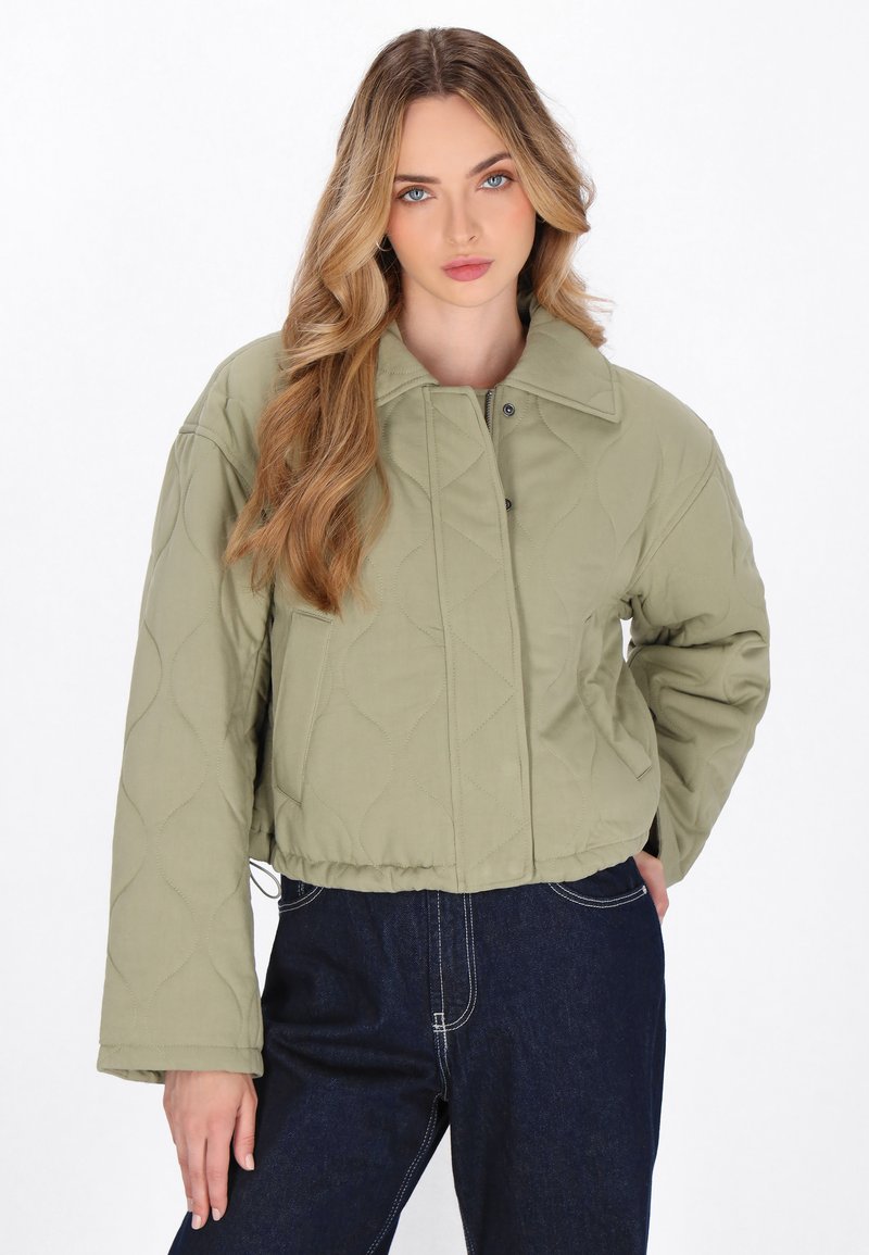 Giacca corta trapuntata in verde oliva, con colletto a camicia, chiusura a scatti e tasche laterali. Morbido al tatto con un design leggero.