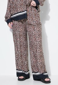 Matchande topp- och byxuppsättning i leopardmönster, tillverkad av mjukt tyg. Har svarta randiga detaljer vid ärmsluten och byxkanterna. Bekväm vid byxpassform.