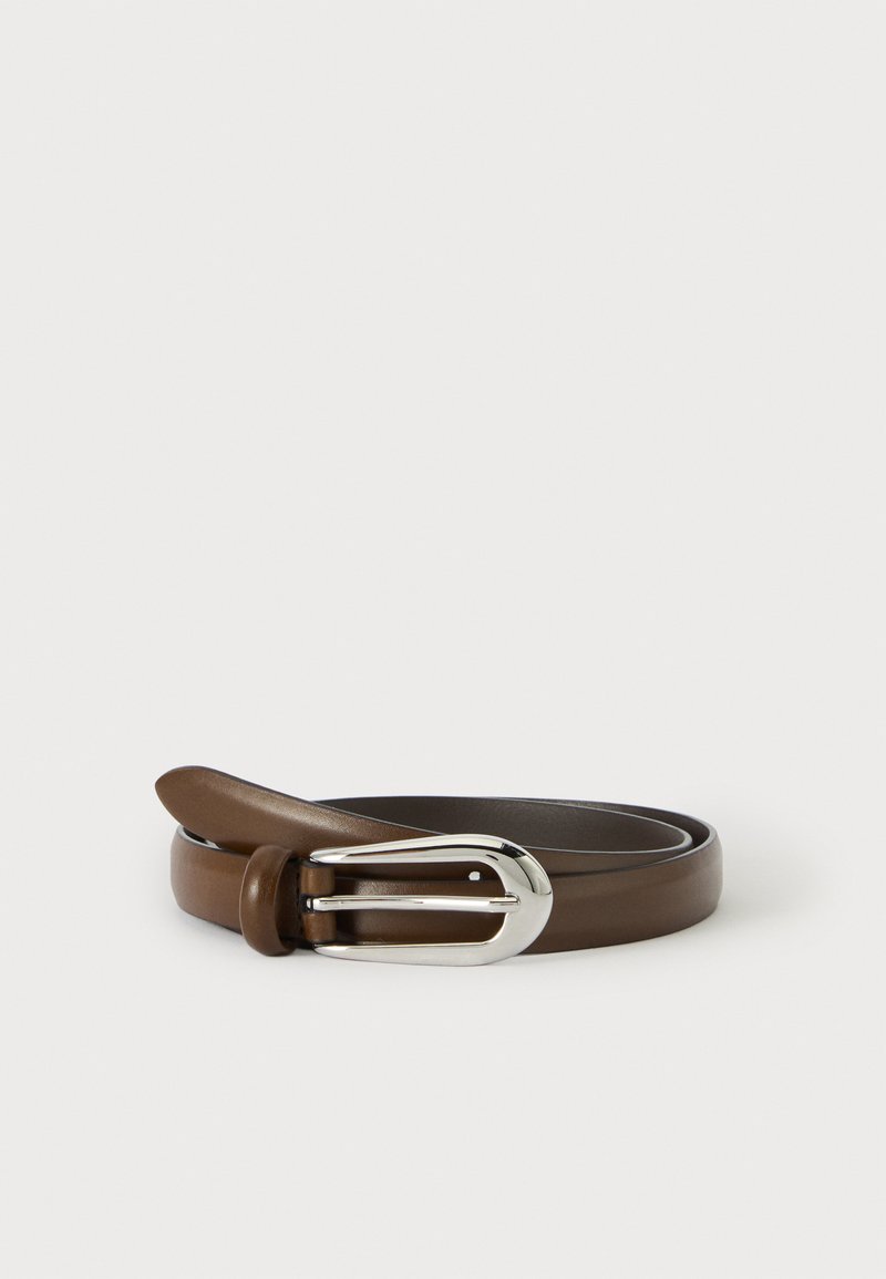 Ceinture en cuir marron roulée avec une boucle en métal argenté sur un fond clair uni.