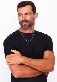 Un tricou scurt negru, purtat de un bărbat cu o brățară din aur deschis. Tricoul are o textură netedă și un decolteu clasic de tip crew.