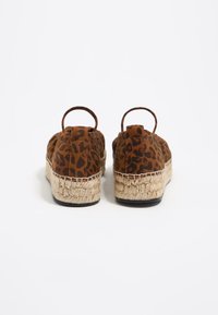 Pruunist sametist espadrillid leopardimustriga, millel on jute vaheosa ja riidest silmus kandadel mugavaks selga panemiseks.