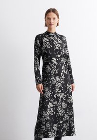 Langermet svart kjole med grå blomster mønster, høy hals, slim fit, laget av et glatt stoff, kne-length med rett hem.
