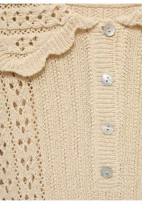 Kremowy, dziergany kardigan z falbaniastym kołnierzem, ozdobiony dekoracyjnymi wzorami koronkowymi i czterema okrągłymi, perłowymi guzikami z przodu.