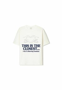 White cotton t-shirt featuring a graphic design of two hands forming a heart, with navy blue text reading "THIS IS THE CLOSEST... I Get To Showing Emotions."