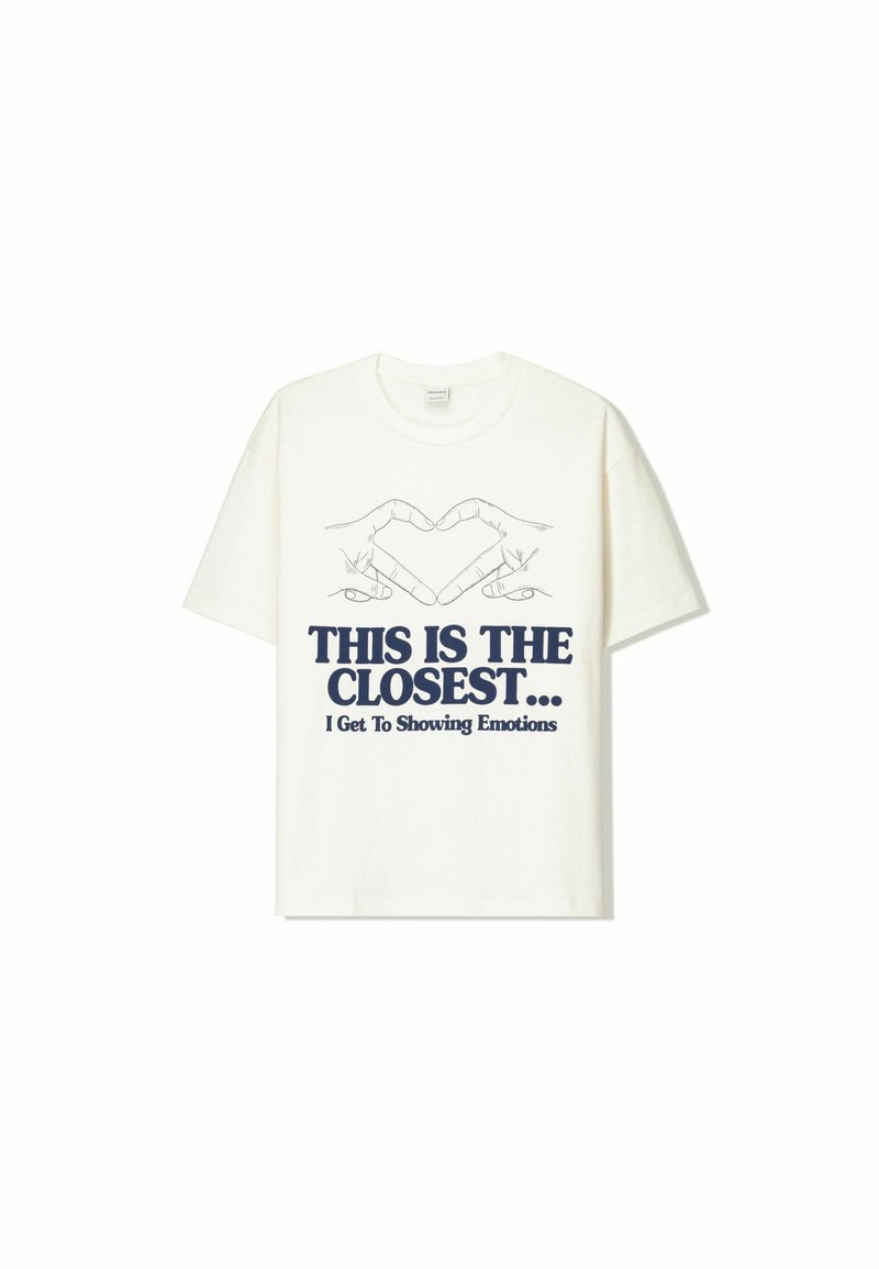White cotton t-shirt featuring a graphic design of two hands forming a heart, with navy blue text reading "THIS IS THE CLOSEST... I Get To Showing Emotions."