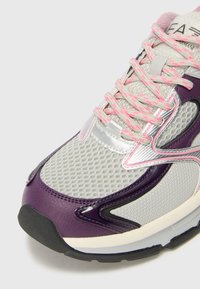 Sneaker med övre del i grått mesh, lila läderdetaljer och silverfärgad hårdvara. Utrustad med rosa snörning och strukturerad sula för bra grepp.