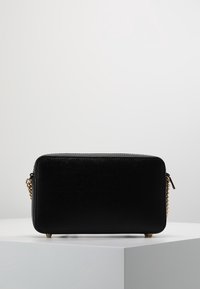 Czarna prostokątna torebka wykonana z teksturowanej skóry. Posiada złoty łańcuszkowy pasek i zamek błyskawiczny. Matowa powierzchnia z metalowymi stopkami.