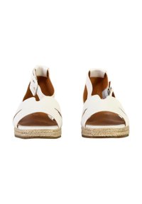Sandales ouvertes blanches avec des brides découpées, intérieur beige et semelle intermédiaire en jute tressé. Design minimaliste avec une bride de cheville sécurisée.