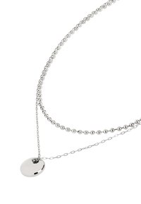 Collier en argent composé de deux chaînes : l'une avec des perles rondes, l'autre avec des maillons. Il présente un pendentif circulaire poli comme point focal.