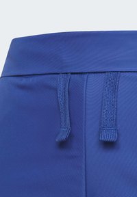 Ceinture en tissu bleu avec cordons de serrage réglables. Texture lisse, forme incurvée, fermeture sécurisée et sans motifs ni accents visibles.