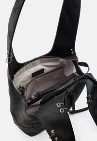 Borsa a mano in pelle nera con superficie morbida e strutturata. Presenta più scomparti, un interno di colore chiaro e dettagli metallici.