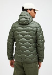 Puffy green jacket with a wavy quilted pattern, featuring a hood and a glossy finish. The back shows a fitted design with elastic cuffs.
