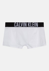 Hvite boxershorts laget av myk bomull, med et svart elastisk midjebånd der "CALVIN KLEIN" er trykt med hvite bokstaver.