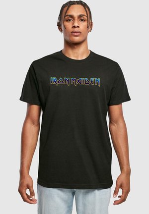 Sort bomulds T-shirt med "IRON MAIDEN" i flerfarvet, stiliseret skrift hen over brystet. Korte ærmer og runde halsudskæring.