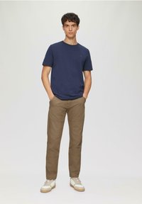 Marine crew-neck t-shirt, kaki broek met naaddetails en witte sneakers met beige accenten. Eenvoudig ontwerp, casual pasvorm en gestructureerde stof.