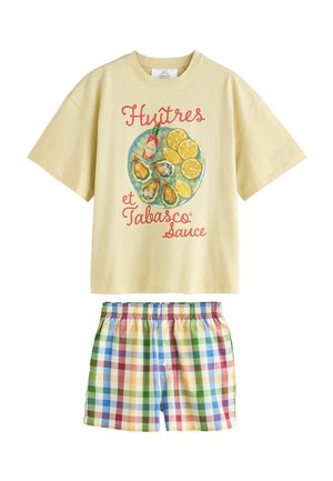 Beige short-sleeve t-shirt with oysters, lemon, Tabasco sauce illustration and red text, paired with multicolor checkered shorts.