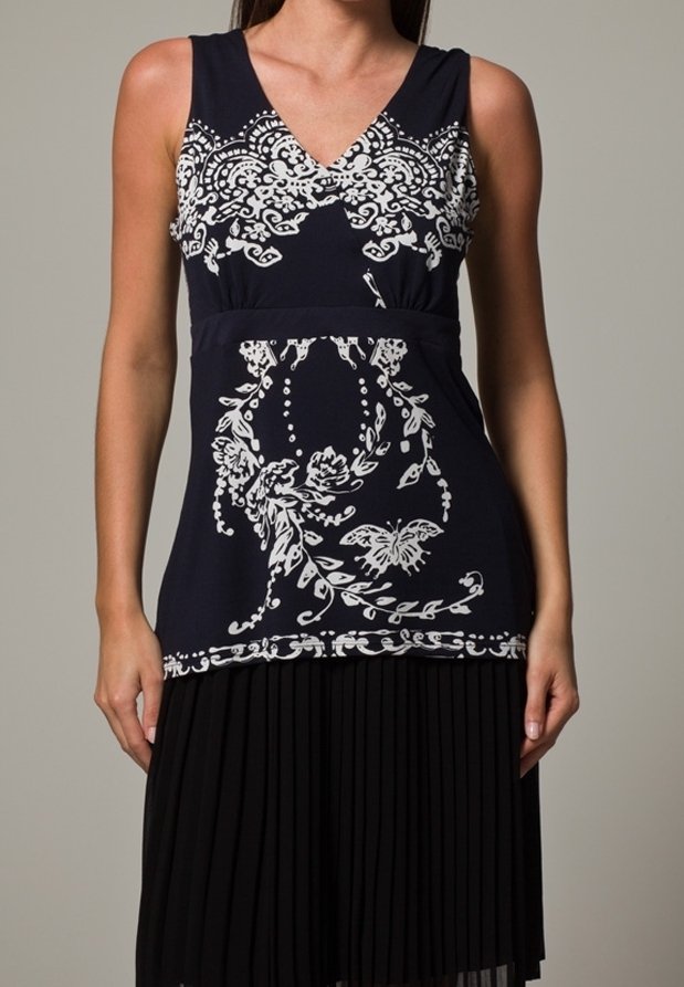 Robe bleu marine avec motifs floraux blancs et papillons. Jupe plissée noire. Encolure en V avec un corsage ajusté. Texture de tissu lisse.