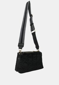 Borsa nera con un motivo floreale testurizzato, dotata di chiusura con zip e tracolla regolabile a strisce nera e grigia. Forma rettangolare.