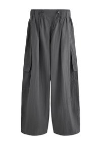 Pantalon large gris foncé avec taille élastique, fermeture par cordon et poches à rabat de chaque côté.