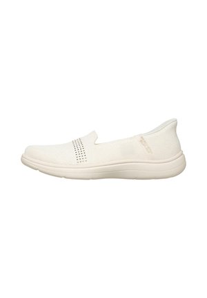 Zapatilla blanca sin cordones con tejido transpirable, suela acolchada y pequeñas tachuelas decorativas en la parte superior.