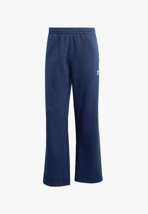 Tumši zili sporta bikses no mīksta auduma ar elastīgu jostasvietu, plašām kājām un mazu baltu logo detaļu uz augšstilba.