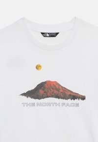 Λευκό T-shirt με γραφικό που απεικονίζει ένα βουνό σε κόκκινους τόνους, έναν κίτρινο ήλιο από πάνω και το κείμενο "THE NORTH FACE" κάτω από το βουνό.
