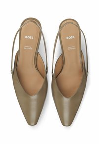 Scarpe slingback in pelle verde oliva con punta a punta, caratterizzate da una parte anteriore a forma di V e una soletta con marchio, progettate per il comfort.