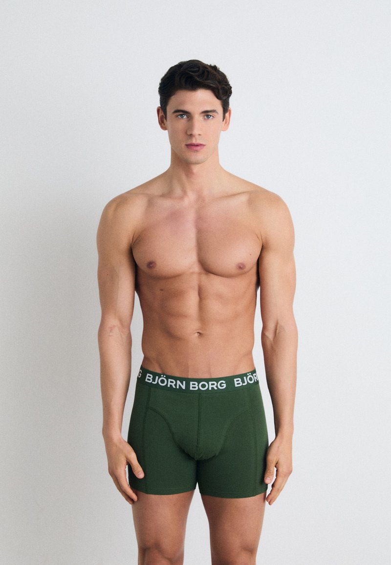 Green boxer briefs with a snug fit, featuring a white elastic waistband labeled "BJÖRN BORG." Smooth texture and no visible patterns.