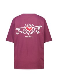 T-shirt en coton bordeaux avec un graphisme représentant une aile blanche et un cœur rouge au dos, avec "Keith Haring" imprimé en dessous du design.