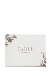 Biely box s kvetinovými akcentmi v jemnej ružovej a zelenej na rohoch. Text "FABLE ENGLAND" v elegantnom písme, zarovnaný na stred v tmavosivej farbe.