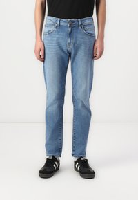 Light blue denim jeans with a straight fit, featuring classic five-pocket styling, a button fly, and slight fade detail on the fabric.