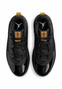 Czarno-złote trampki typu low-top z błyszczącymi noskami, czarnymi sznurowadłami oraz białym logo Jumpman widocznym wewnątrz każdego buta.